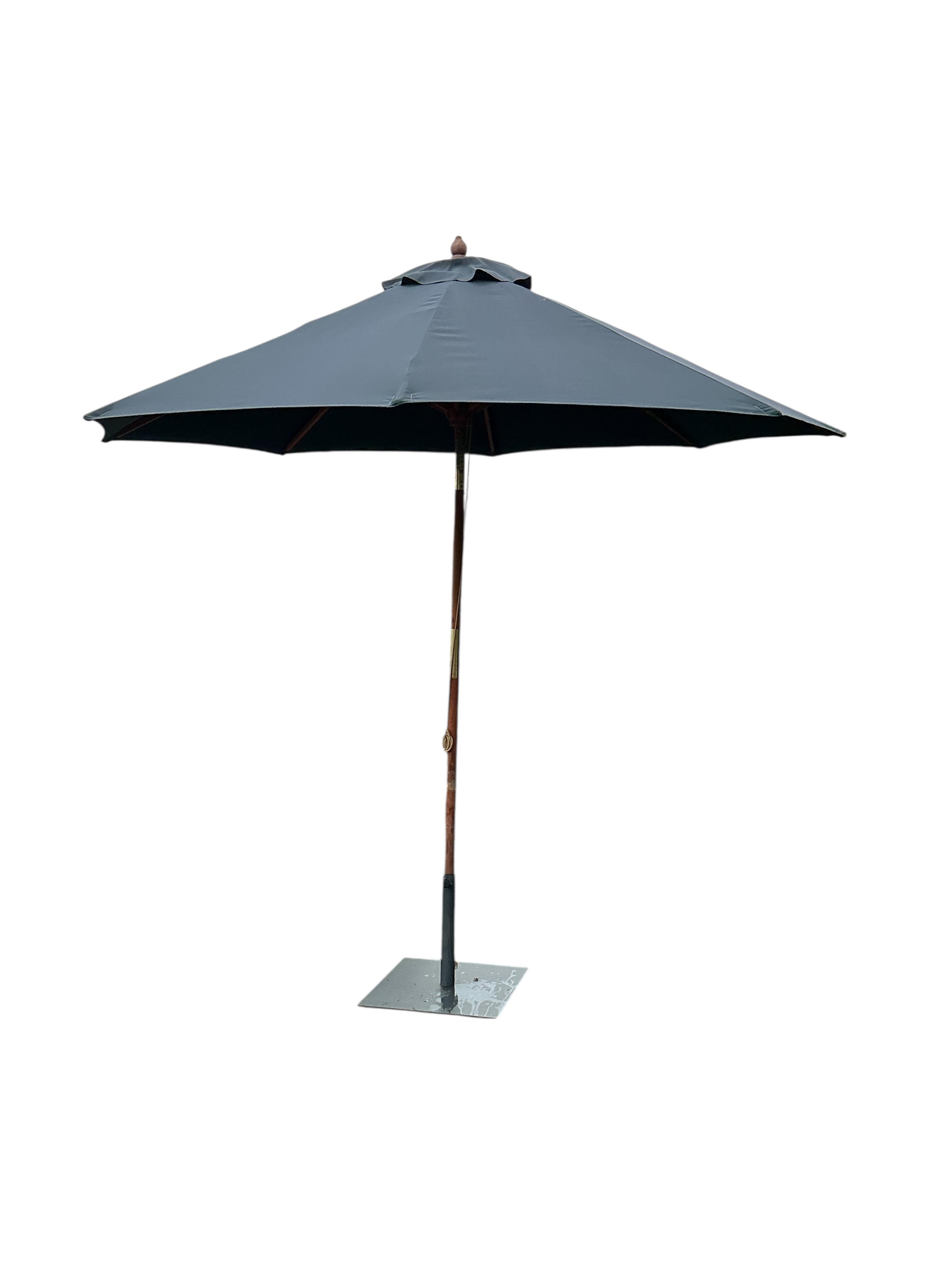 An Indian Ocean Trading Company rectangular teak extending garden table, width 164cm, depth 90cm, height 74cm, four folding chairs and a canvas parasol with metal stand
